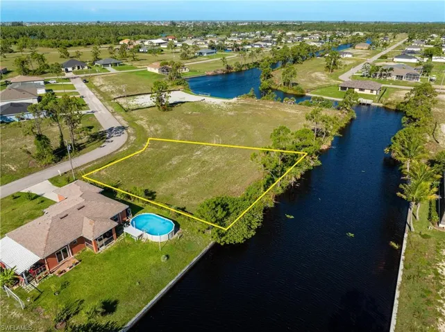 Aerial view of residential area featuring property parcel outlined and a large body of water