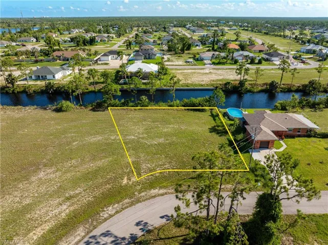 Aerial view of residential area with property parcel outlined and a large body of water