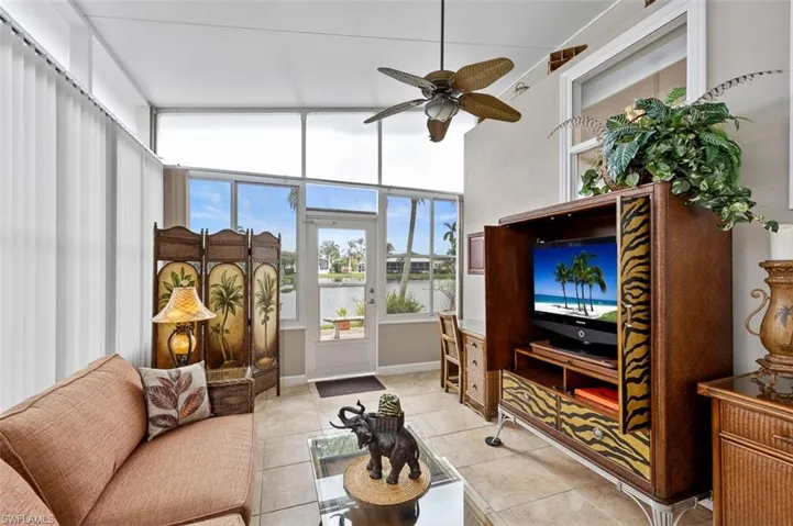 Living room featuring ceiling fan, light tile patterned floors, and high vaulted ceiling