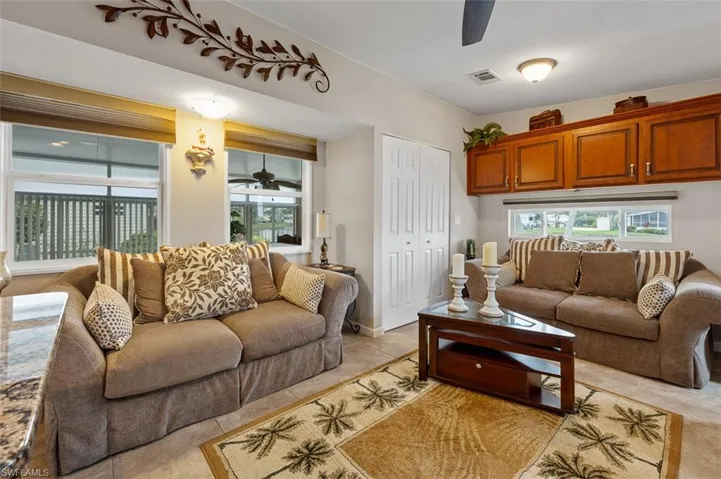 Living room with ceiling fan and light tile patterned floors