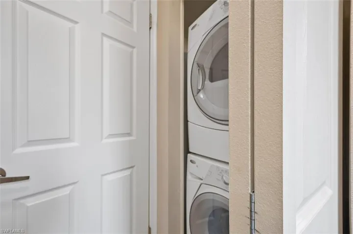 Laundry room with stacked washer and clothes dryer