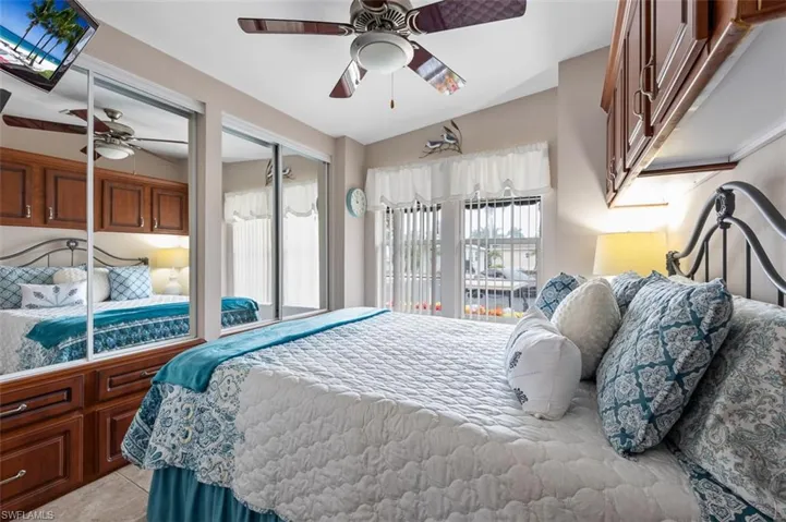 Tiled bedroom featuring ceiling fan and a closet