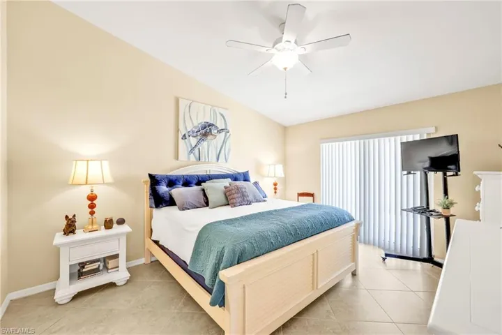 Bedroom with baseboards, lofted ceiling, ceiling fan, and light tile patterned floors