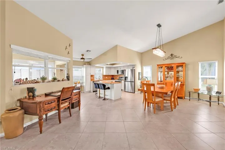 Dining area featuring baseboards, high vaulted ceiling, and light tile patterned flooring