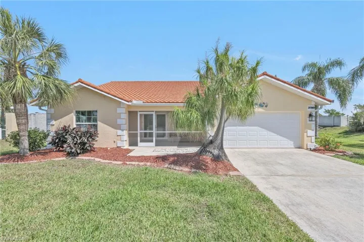 Ranch-style home featuring a front lawn, stucco siding, an attached garage, a tile roof, and driveway