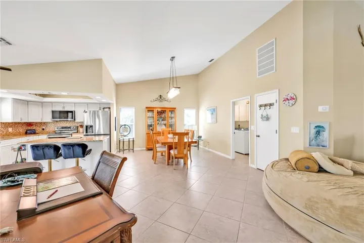Dining area featuring baseboards, visible vents, high vaulted ceiling, and light tile patterned flooring