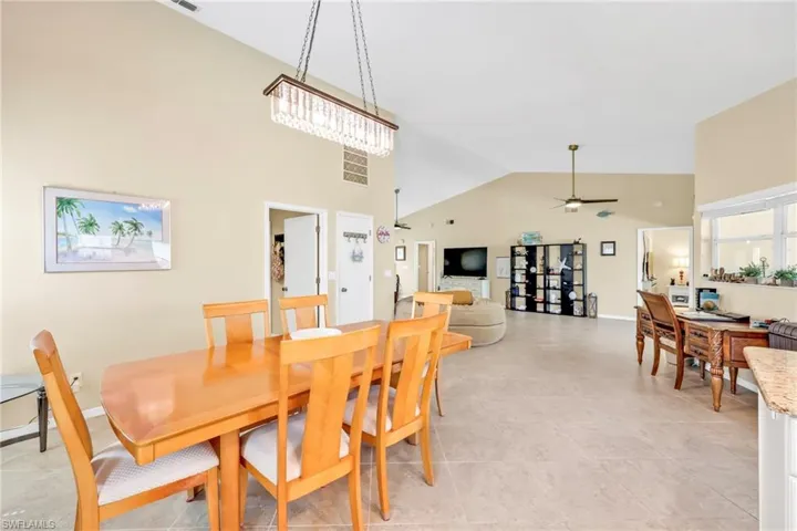 Dining space featuring high vaulted ceiling, baseboards, a ceiling fan, and visible vents