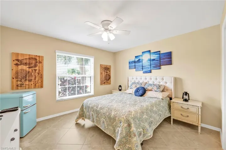 Bedroom with a ceiling fan, baseboards, and light tile patterned flooring