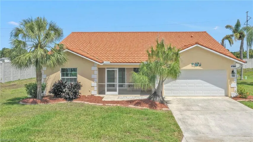 View of front of home featuring concrete driveway, a tiled roof, stucco siding, and a garage