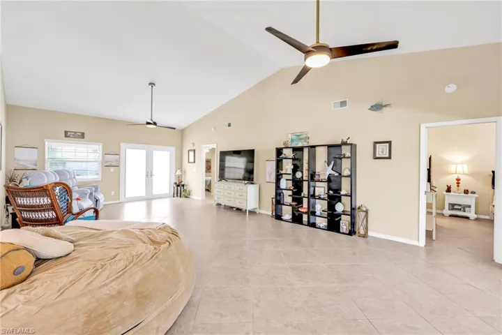 Bedroom featuring high vaulted ceiling, light tile patterned floors, french doors, baseboards, and visible vents