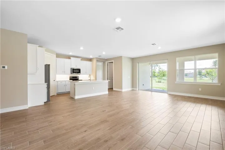 Unfurnished living room with sink and light hardwood / wood-style floors