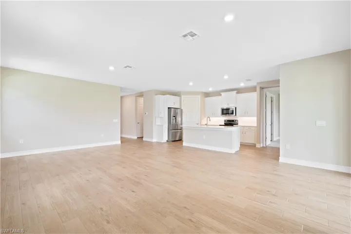 Unfurnished living room featuring light hardwood / wood-style floors and sink