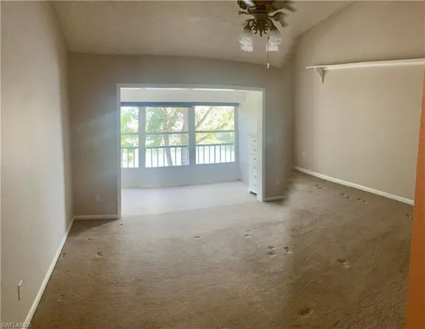 Master bedroom upstairs featuring carpet, a textured ceiling, ceiling fan, and lofted ceiling