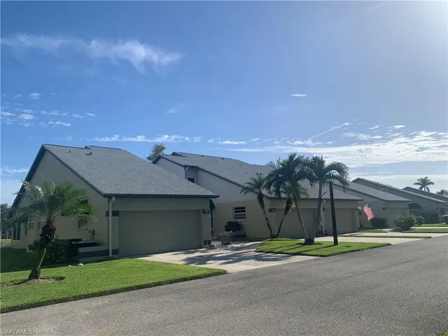 Villa w 4 units with 2 story subjectproperty in middle  featuring a garage and a front lawn