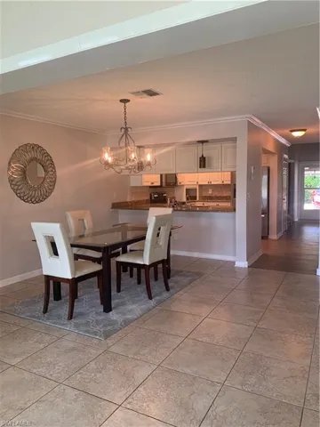 Dining area with an inviting chandelier and ornamental molding