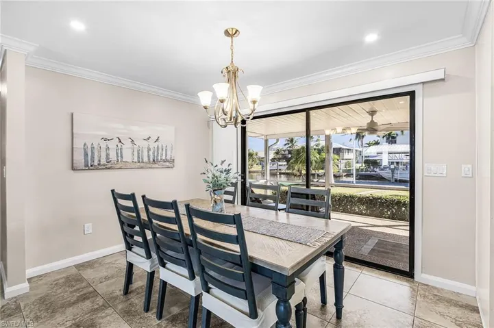 Dining area with hanging lights and ornamental molding