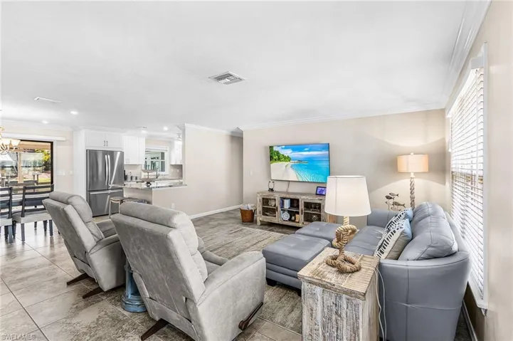 Living area featuring crown molding and hanging lights