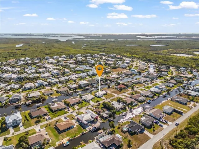 Aerial view of property and surrounding area featuring a large body of water and nearby suburban area