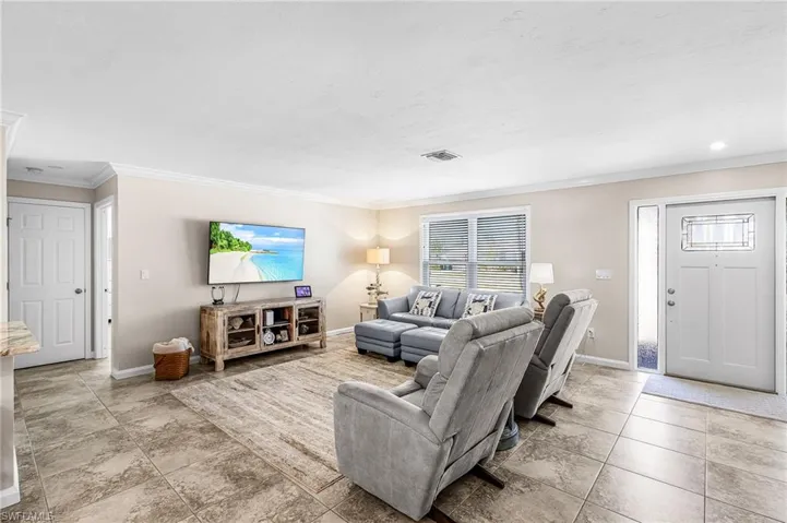 Living area with crown molding and baseboards