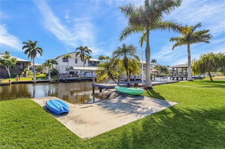 Dock area with a yard, a water view, and a gazebo