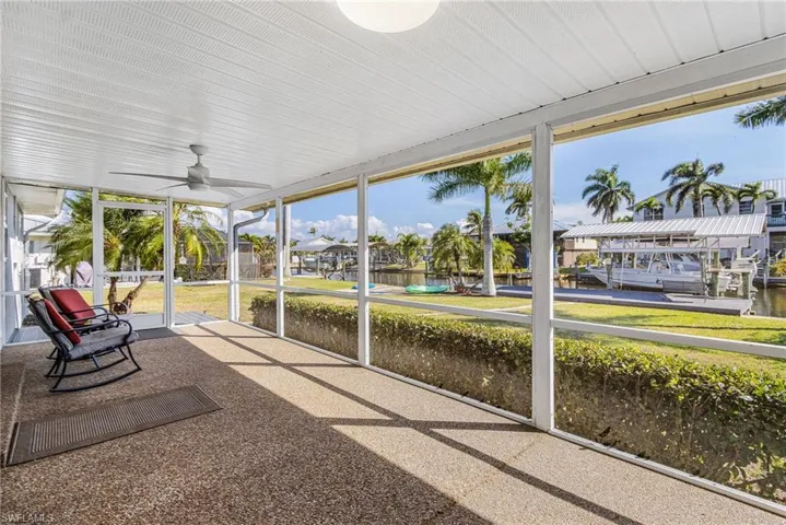 Unfurnished sunroom featuring a ceiling fan and a water view