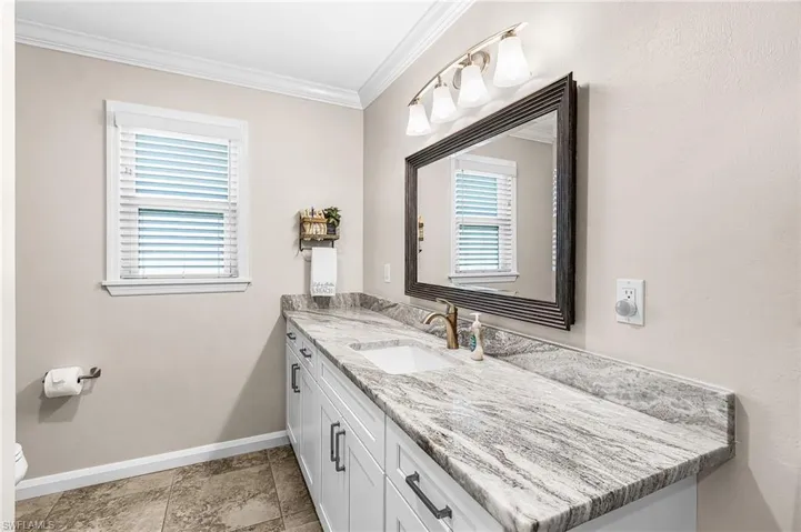 Half bath featuring vanity and crown molding