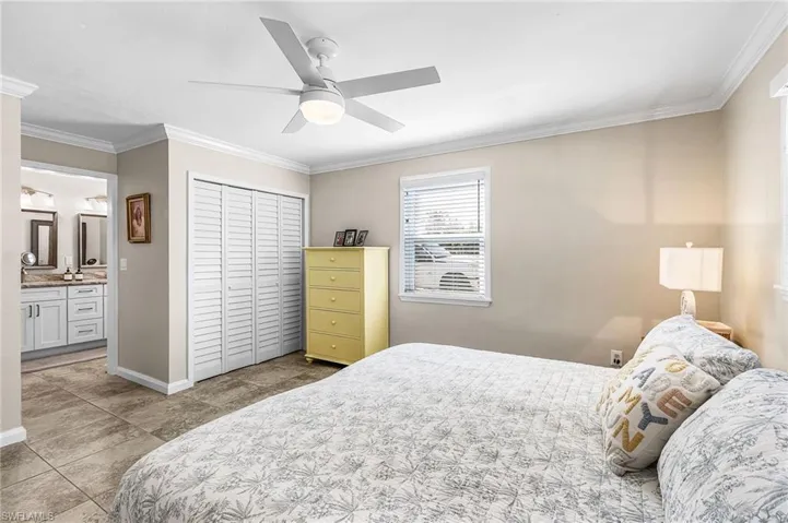 Bedroom featuring crown molding, a closet, ceiling fan, and ensuite bathroom