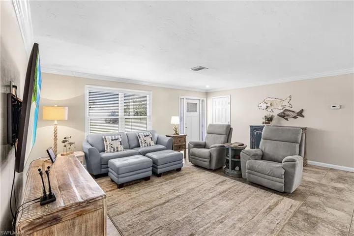 Living room with ornamental molding and baseboards