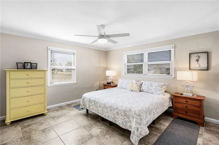 Bedroom featuring a ceiling fan and crown molding