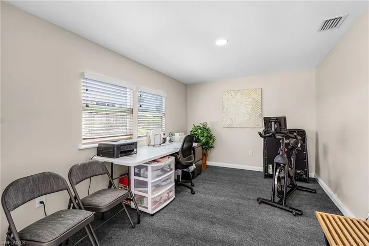 Office featuring dark carpet and baseboards