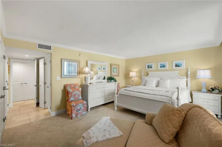 Bedroom with crown molding and light carpet