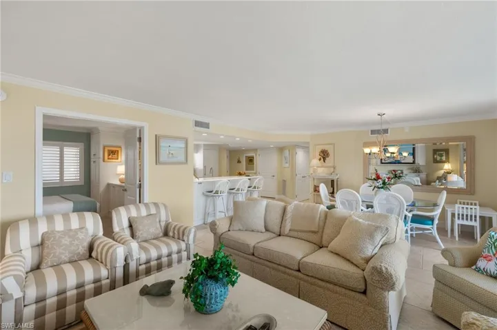Living area with crown molding, tile patterned floors, and a chandelier