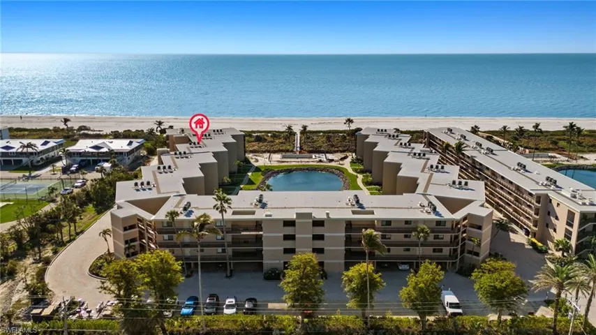 Aerial view of waterfront with a beach and apartment complex / building