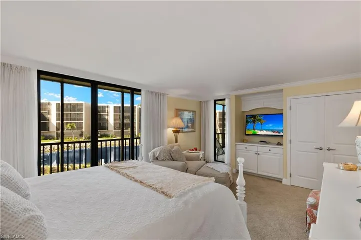 Bedroom featuring light carpet, ornamental molding, and access to outside
