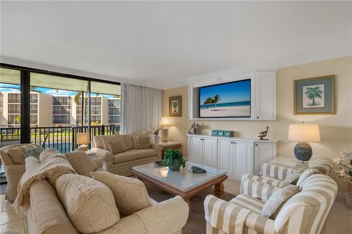 Living area featuring light tile patterned floors, ornamental molding, and expansive windows