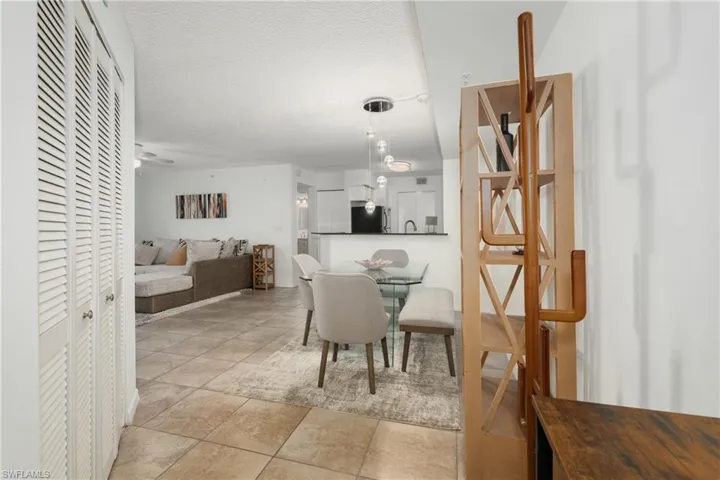 Dining space with light tile patterned flooring, a textured ceiling, and ceiling fan