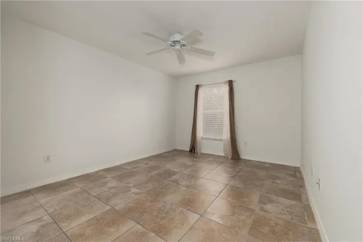 Empty room featuring baseboards and ceiling fan