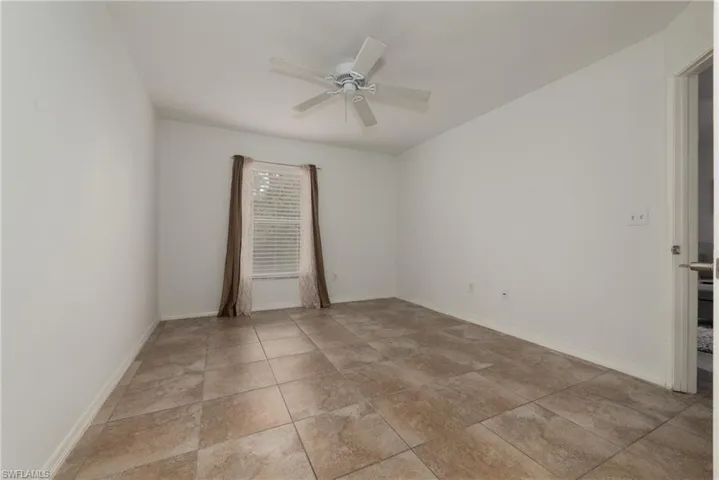Unfurnished room featuring ceiling fan and baseboards