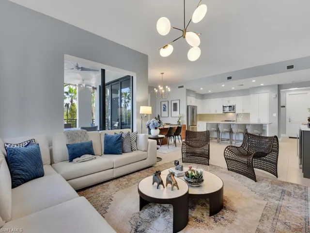 Living area featuring a chandelier, ceiling fan, and light tile patterned floors