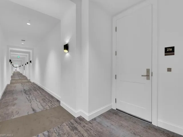 Hallway featuring baseboards and concrete flooring