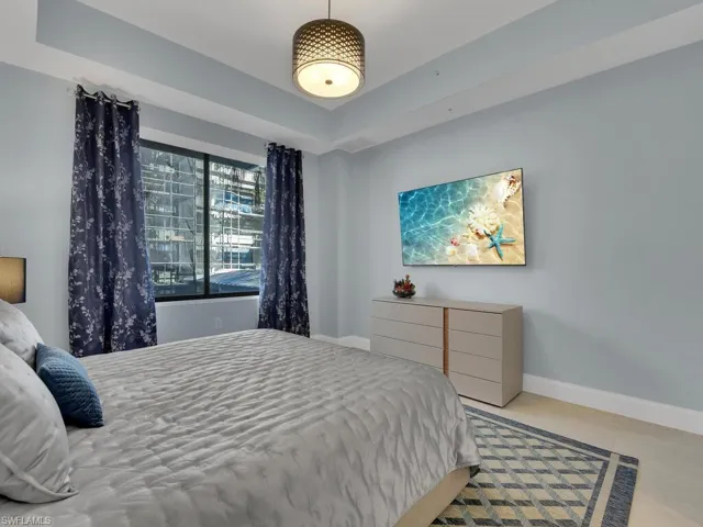 Bedroom featuring light tile patterned floors and a raised ceiling