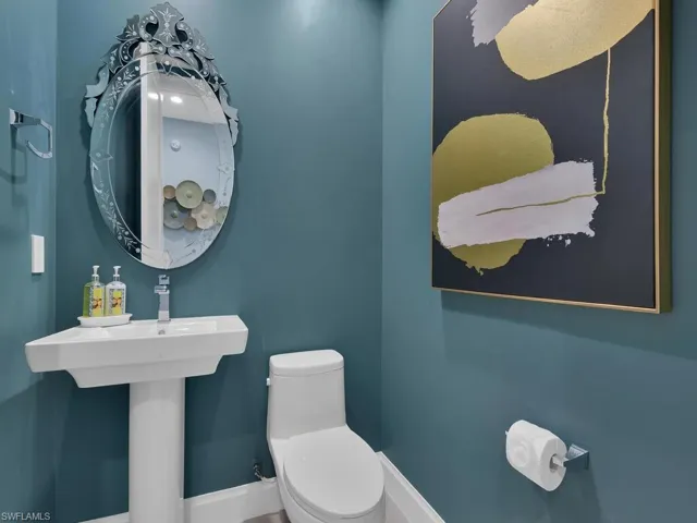 Half bath featuring toilet and baseboards