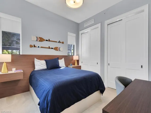 Carpeted bedroom featuring a closet and an office area