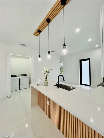 Kitchen island featuring a light-toned countertop, wood-finish paneling, and a black-finish faucet