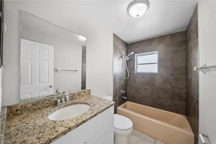 Bathroom with vanity,  shower combination, and light tile patterned floors
