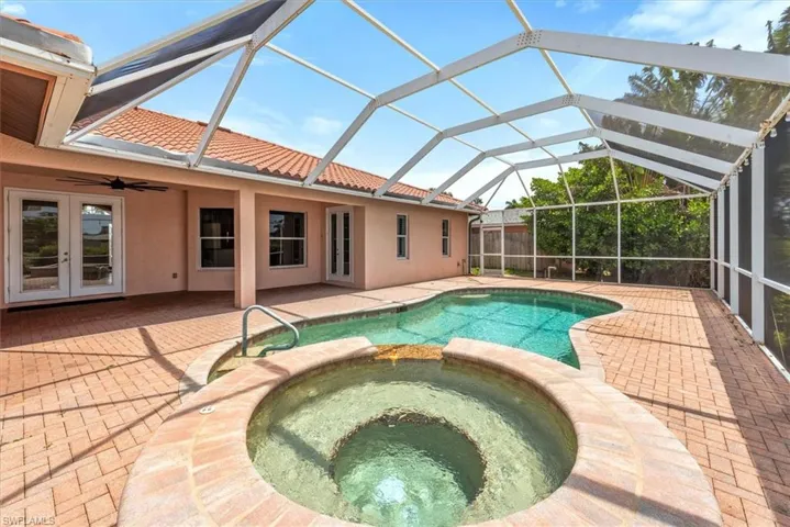 View of pool featuring a pool with connected hot tub, a patio area, french doors, and ceiling fan