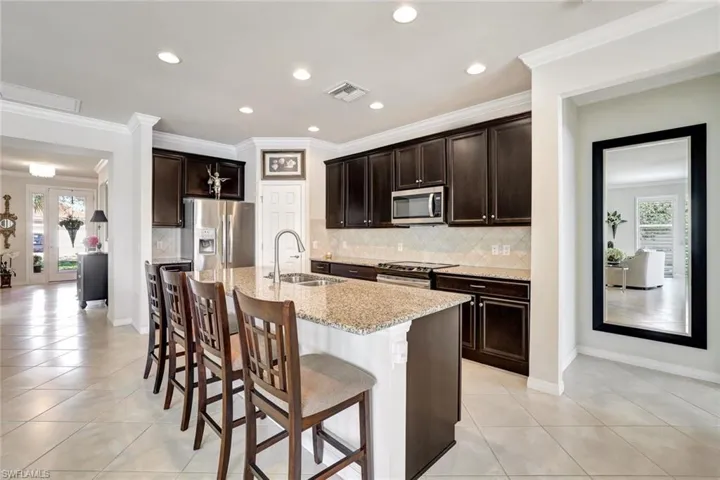 Kitchen with visible vents, appliances with stainless steel finishes, a sink, an island with sink, and plenty of natural light