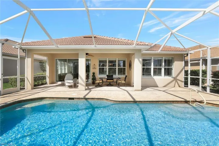 Pool with glass enclosure, a patio, and a ceiling fan