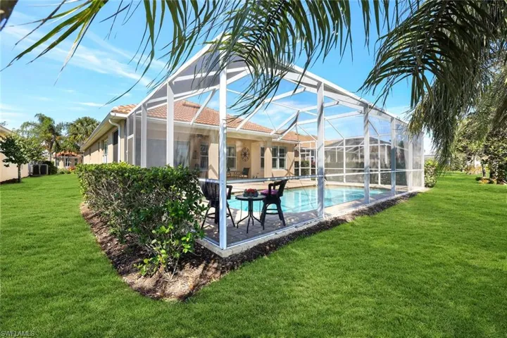 Pool with a lanai, a patio, and a yard