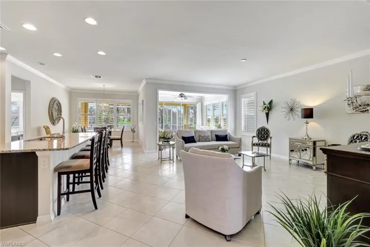 Living room with light tile patterned floors, recessed lighting, visible vents, ornamental molding, and baseboards
